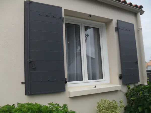 Volets battants PVC sur façade de maison